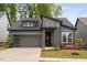 Modern home featuring a dark gray exterior, a two car garage and an inviting front yard at 109 Imagine Way, Pittsboro, NC 27312