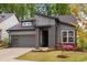 Charming gray home with manicured lawn and pops of pink and red from the floral landscape at 109 Imagine Way, Pittsboro, NC 27312