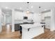 Bright kitchen features white cabinets, an island with bar seating, stainless appliances, and pendant lighting at 109 Imagine Way, Pittsboro, NC 27312