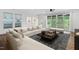 Staged living room featuring modern furniture, wood floors, large windows, and sliding glass doors to the backyard at 109 Imagine Way, Pittsboro, NC 27312