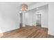 Open living room boasts neutral walls, wood floors, and stylish light fixture at 109 Imagine Way, Pittsboro, NC 27312