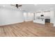 Spacious open floor plan with wood floors extends from the living area into the kitchen featuring white cabinets at 109 Imagine Way, Pittsboro, NC 27312