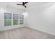 Spacious bedroom with tray ceiling, ceiling fan, carpet, and large windows that provide exterior views at 109 Imagine Way, Pittsboro, NC 27312