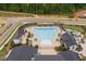 Aerial view of a community pool featuring lounge chairs, shaded pergolas, and well-maintained landscaping at 109 Imagine Way, Pittsboro, NC 27312