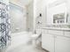 Well-lit bathroom featuring a shower-tub combo, white vanity, and neutral tile at 1121 Coast Grade St, Wake Forest, NC 27587