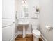 Stylish powder room features pedestal sink, patterned wallpaper, and hardwood floors at 1121 Coast Grade St, Wake Forest, NC 27587