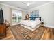 Bright bedroom features a plush rug, ceiling fan, and large window at 1121 Coast Grade St, Wake Forest, NC 27587