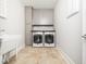 Efficient laundry room with front load washer and dryer, cabinets, and utility sink at 1121 Coast Grade St, Wake Forest, NC 27587