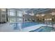 Indoor pool area with large windows, a hot tub, and comfortable lounge chairs at 1121 Coast Grade St, Wake Forest, NC 27587