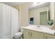 Well-lit bathroom featuring a shower with a white curtain and a vanity with neutral cabinets at 114 Red Robin Rd, Durham, NC 27703