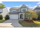 Inviting two-story home featuring a two-car garage, covered porch, and charming curb appeal at 114 Red Robin Rd, Durham, NC 27703