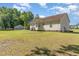 Open backyard featuring home exterior, ample green space, and storage shed at 116 Meade Dr, Four Oaks, NC 27524