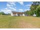 Spacious backyard featuring lush lawn, mature trees, outbuilding and home at 116 Meade Dr, Four Oaks, NC 27524