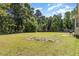 Spacious backyard with mature trees offering privacy and a shed in view at 116 Meade Dr, Four Oaks, NC 27524