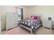Well-lit bedroom with patterned bedding, wooden furniture, and pink accents at 116 Meade Dr, Four Oaks, NC 27524