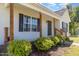 Welcoming covered front porch with wooden columns, lush landscaping, and security system at 116 Meade Dr, Four Oaks, NC 27524