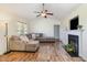 Spacious living room featuring wood floors, ceiling fan, fireplace, and plenty of natural light at 116 Meade Dr, Four Oaks, NC 27524