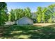 Side view of home with well-maintained backyard and surrounded by mature trees at 116 Shawnee Dr, Louisburg, NC 27549
