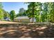Back view of the single Gathering home featuring a flat backyard and mature trees at 116 Shawnee Dr, Louisburg, NC 27549