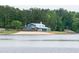 Lakefront community building with beach, green trees, and clear water at 116 Shawnee Dr, Louisburg, NC 27549
