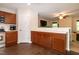 An open kitchen offers wooden cabinets and counter seating, with a view into the living room at 116 Shawnee Dr, Louisburg, NC 27549