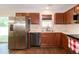 Galley kitchen with stainless steel appliances, double sink, and wood cabinetry at 116 Shawnee Dr, Louisburg, NC 27549