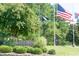 Entrance to Lake Royale community featuring lush landscaping and flags at 116 Shawnee Dr, Louisburg, NC 27549