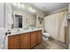 Well-lit bathroom features a double vanity and a shower with a neutral curtain at 1204 Caribou Xing, Durham, NC 27713