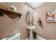 Well-lit half bathroom with a pedestal sink, mirror, and neutral color palette at 1204 Caribou Xing, Durham, NC 27713