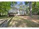 Back of the home featuring a spacious backyard, a wooden deck, and mature trees providing ample shade at 128 Cobblestone Dr, Chapel Hill, NC 27516