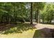 View of the expansive backyard with mature trees and a shed behind a wood fence at 128 Cobblestone Dr, Chapel Hill, NC 27516