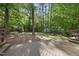 Wood deck featuring built-in seating, overlooking a serene backyard with mature trees at 128 Cobblestone Dr, Chapel Hill, NC 27516
