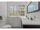 Bathroom with dark wood vanity, large mirror and a window offering a treed view at 128 Cobblestone Dr, Chapel Hill, NC 27516
