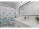 Bathroom featuring single sink, white cabinets, a large mirror, and decorative shower curtain at 128 Cobblestone Dr, Chapel Hill, NC 27516