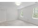 Light-filled bedroom features soft carpet and large bright windows with leafy views at 128 Cobblestone Dr, Chapel Hill, NC 27516