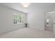 Bright bedroom featuring neutral carpet, light walls, and a window with views of the outside at 128 Cobblestone Dr, Chapel Hill, NC 27516