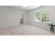 Spacious bedroom with soft carpet, bright windows, and a hallway entrance at 128 Cobblestone Dr, Chapel Hill, NC 27516