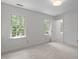 Bright bedroom with neutral decor, soft carpet, and multiple light-filled windows at 128 Cobblestone Dr, Chapel Hill, NC 27516