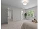 View of bedroom with ensuite bathroom, soft carpet, and a leafy window view at 128 Cobblestone Dr, Chapel Hill, NC 27516