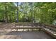 Large wood deck offering seating surrounded by a lush green forest at 128 Cobblestone Dr, Chapel Hill, NC 27516