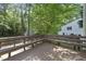 Wood deck with built-in bench seating surrounded by lush greenery for outdoor relaxation at 128 Cobblestone Dr, Chapel Hill, NC 27516