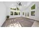 Bright living room featuring large windows, vaulted ceiling, and a ceiling fan at 128 Cobblestone Dr, Chapel Hill, NC 27516