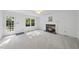 Bright living room with a brick fireplace, white trim, and large windows at 128 Cobblestone Dr, Chapel Hill, NC 27516