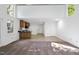 Open living space with partial kitchen, white walls, and neutral flooring at 128 Cobblestone Dr, Chapel Hill, NC 27516