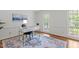Bright home office with hardwood floors, a modern white desk, and a large window at 128 Cobblestone Dr, Chapel Hill, NC 27516