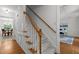 Staircase with wood handrail and carpeted steps connecting the home's levels at 128 Cobblestone Dr, Chapel Hill, NC 27516