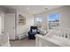 Charming bedroom with a blue armchair, white crib, and natural light from two windows at 138 Boarstall Crk, Durham, NC 27707