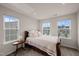 Cozy bedroom with three windows, a bed with many pillows, and an accent table at 138 Boarstall Crk, Durham, NC 27707