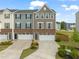 Beautiful townhome with brick accents, a driveway, and a two-car garage, all under a partly cloudy sky at 138 Boarstall Crk, Durham, NC 27707