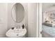 Elegant half-bath with a stylish sink, oval mirror, and a glimpse of the living room at 138 Boarstall Crk, Durham, NC 27707